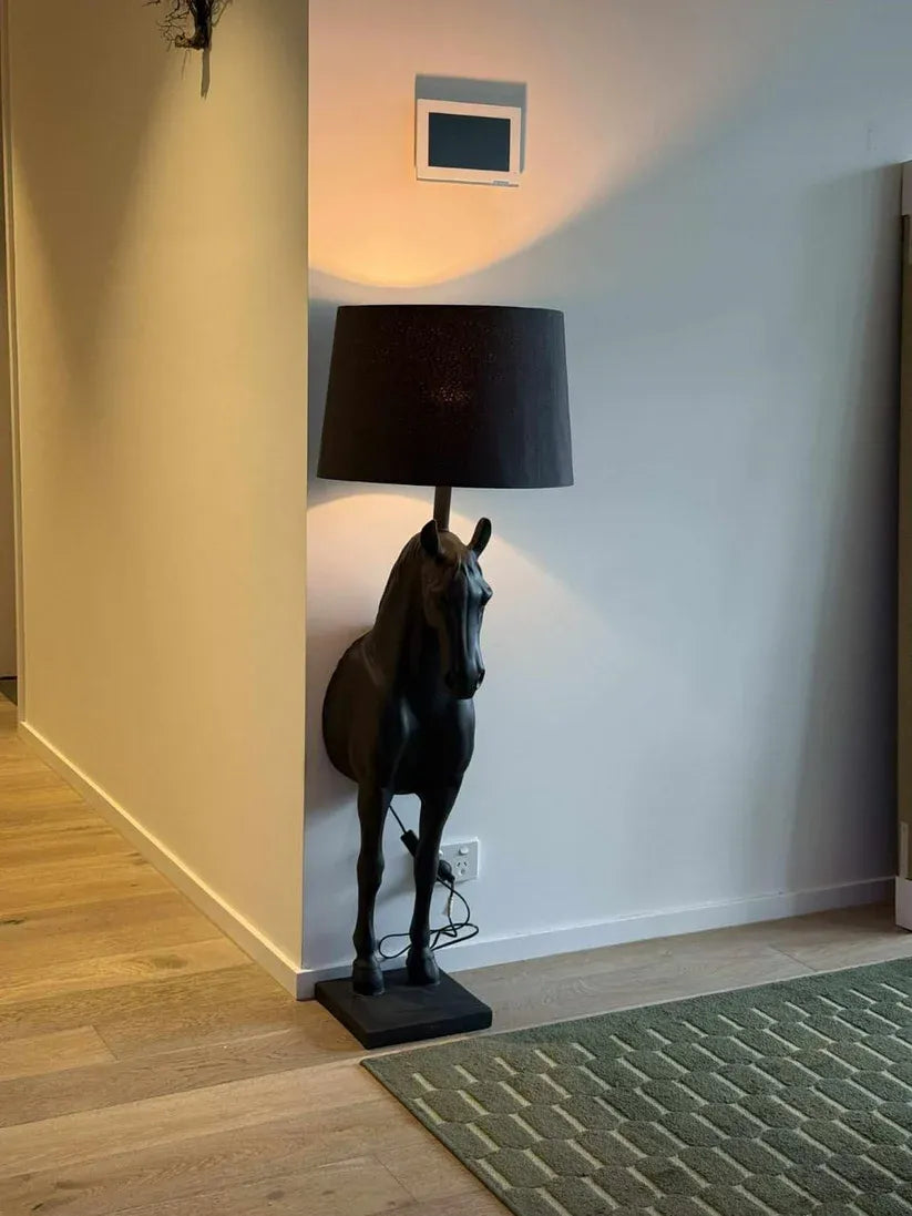 Modern living room with unique horse head wall lamps, neutral sofa, and contemporary decor