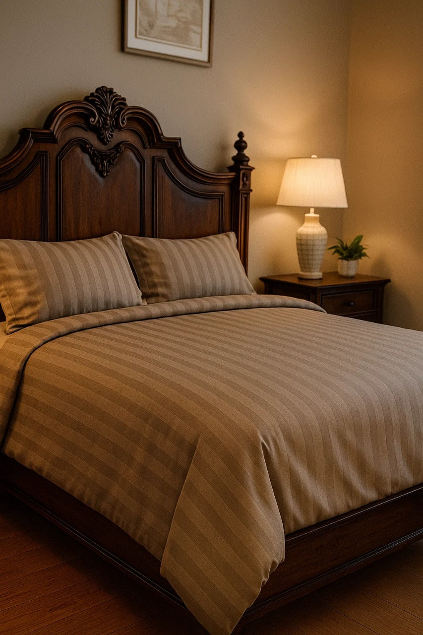 Luxury handmade bedding with striped taupe linens on an ornate wooden bed, warm bedroom decor